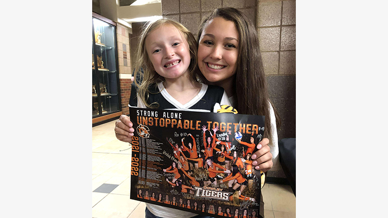 female athlete with child and poster