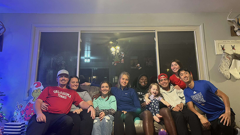 family and students huddled on couch