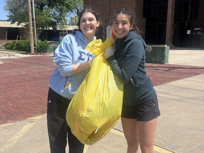 two girls picking up trash