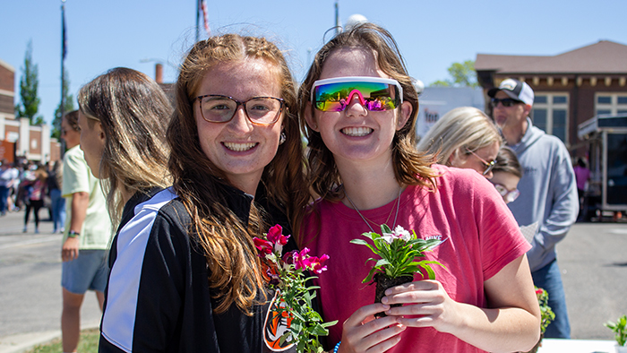 female students on campus holding flowers