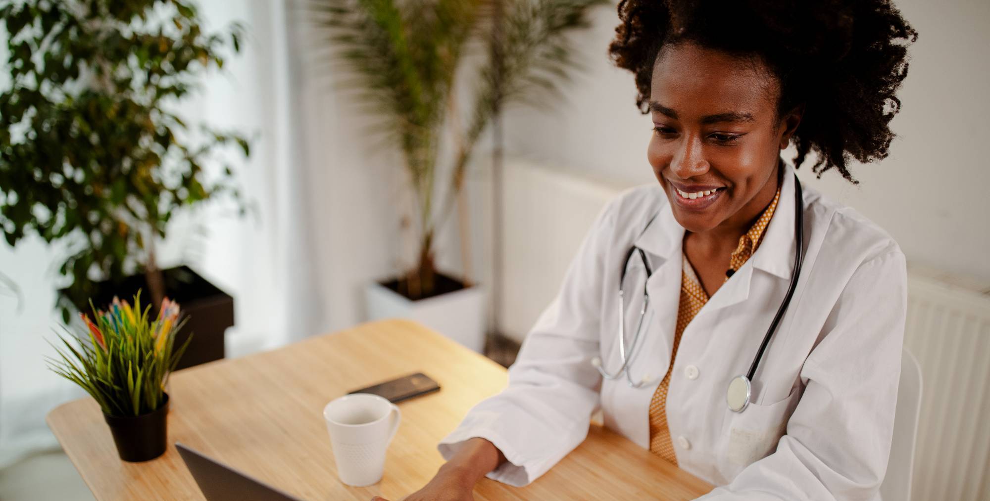 woman in lab coat using laptop