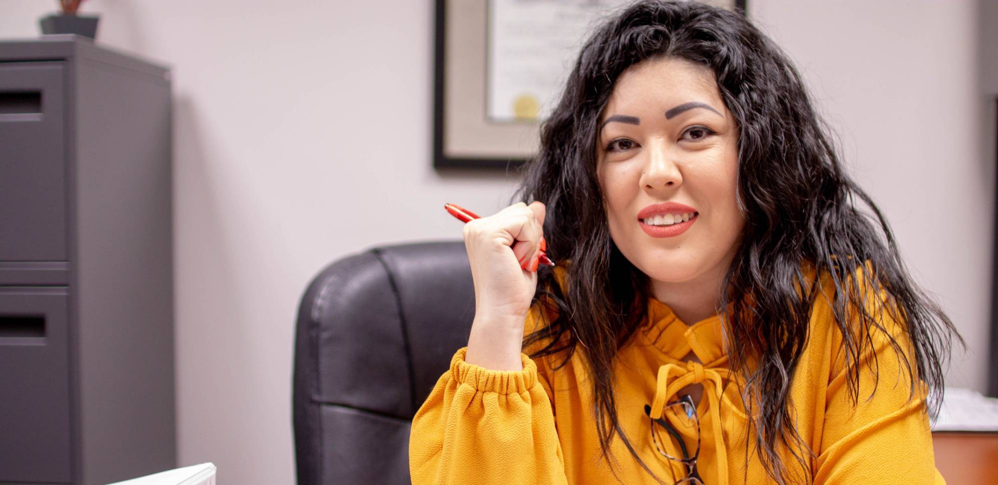 woman at a desk in a yellow shirt