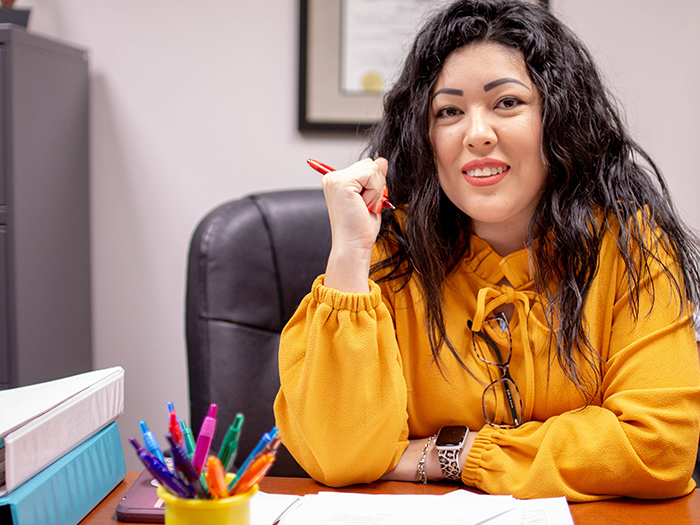 woman at a desk in a yellow shirt